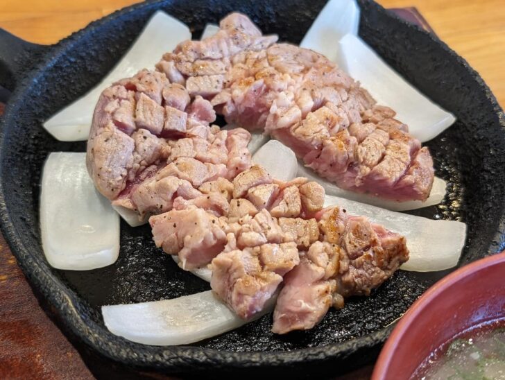 表面だけが焼かれた豚ステーキは、真ん中のペレット（焼き石）で好みの焼き加減に