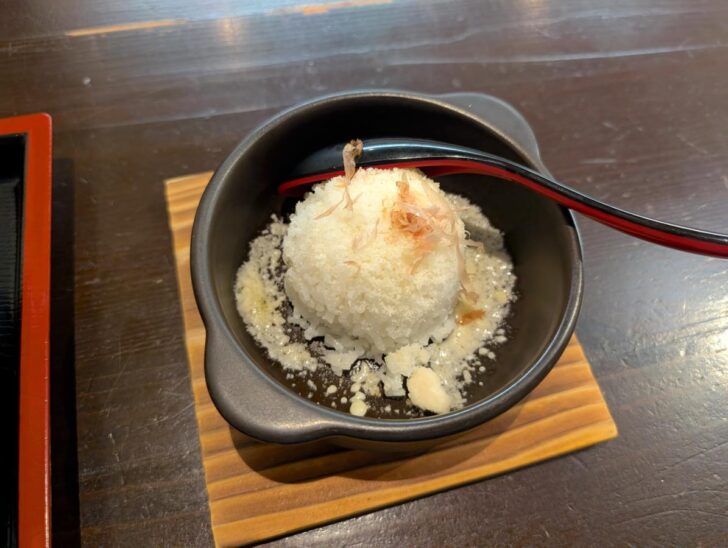 ラーメンのスープを入れて作る追い焚きリゾットは、熱々の鉄鍋で提供されるこだわり