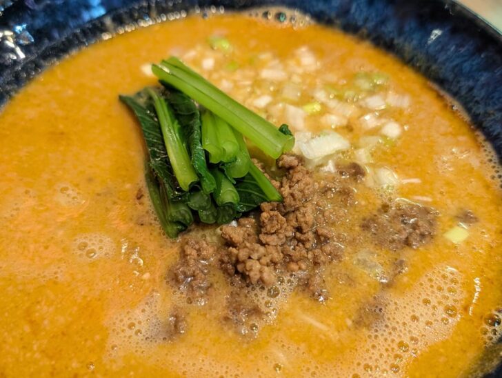 濃厚そうなスープの上には、ひき肉、ネギ、それにほうれん草（小松菜？）が乗っている